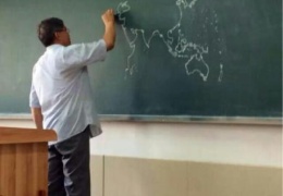 Учитель географии рисует на доске карту мира
