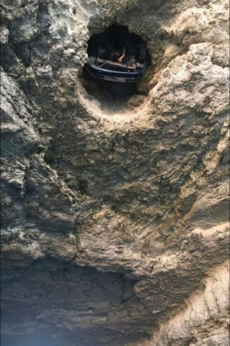 Автомобиль, падая в море, застрял в скале