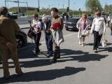 Люди несут цветы к Бронзовому солдату 