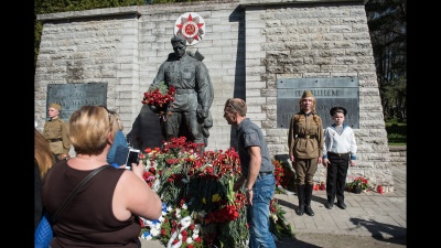 Люди несут цветы к Бронзовому солдату 